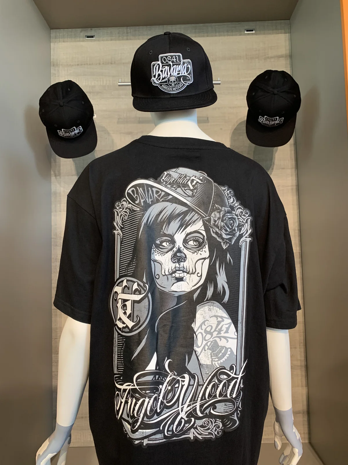 Schwarzes T-Shirt von hinten mit Rückenmotiv und Snapback-Cap