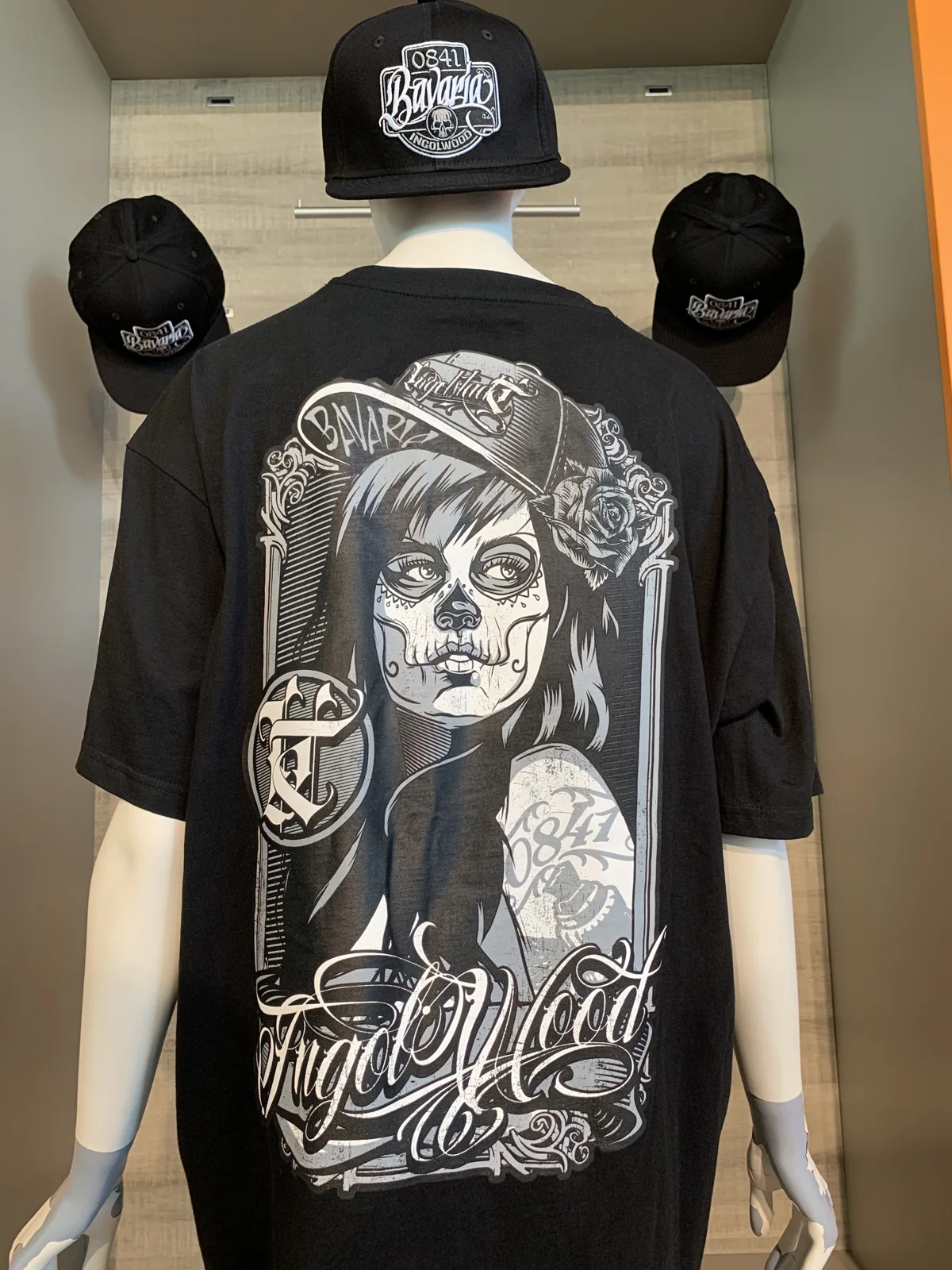 Schwarzes T-Shirt von hinten mit großem Rückenmotiv: Frau mit Cap und Rosen